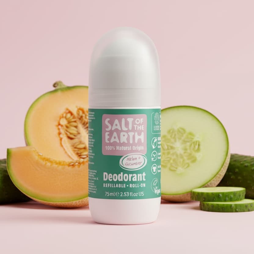 Roll-on deodorant with melon and cucumber slices on a pink background